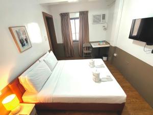 a hotel room with a bed and a television at ZKB Twins Hotel in General Santos +19 photos