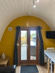a room with an arched doorway with a sliding glass door at Acorns Luxury Glamping in Holywell