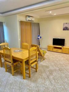 a dining room with a table and chairs and a television at Monte Do Bem-Estar Tarrafal in Tarrafal