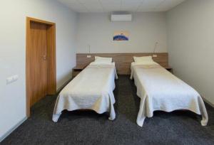 a hospital room with three beds with white blankets at Air Kaunas in Karmėlava +2 photos