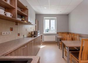 a kitchen with wooden cabinets and a table and chairs at Air Kaunas in Karmėlava