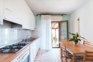 a kitchen with white cabinets and a wooden table at Residence azzurro VISTA MARE-A in Gabicce Mare