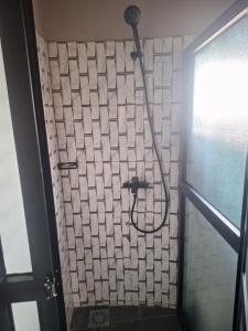 a shower with a hose attached to a tiled wall at MANGALA Hotel BIO in Palimé +33 photos