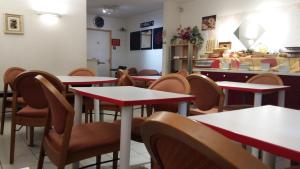 Un restaurante con mesas y sillas y un mostrador. en Bonsaï Hotel d'Orleans, en Olivet