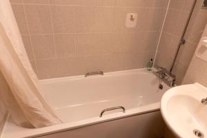 a bathroom with a white tub and a sink at De Trafford Arms by Chef & Brewer Collection in Alderley Edge +20 photos
