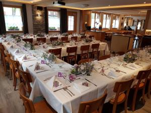 a room with long tables and chairs with white tablecloths at Hotel Altels in Kandergrund