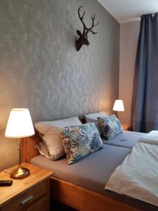 a bedroom with two beds and a deer head on the wall at Pension am Park in Oschatz +8 photos
