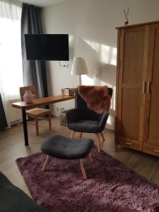 a living room with a chair and a desk at Pension am Park in Oschatz