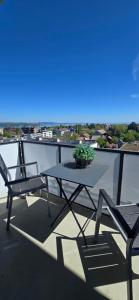 a table and chairs on a balcony with a potted plant at Lake View See & Bergsicht free parking in Kreuzlingen