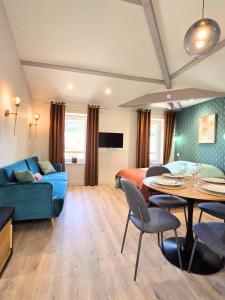 a living room with a blue couch and a table at Le Nid Douillet Studio in Saint-Affrique