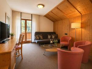 ein Wohnzimmer mit Sofa, Tisch und Stühlen in der Unterkunft first mountain Hotel Montafon in Gaschurn