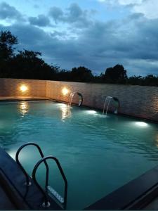 a swimming pool at night with lights on a wall at Shivoham holiday villa in Dapoli