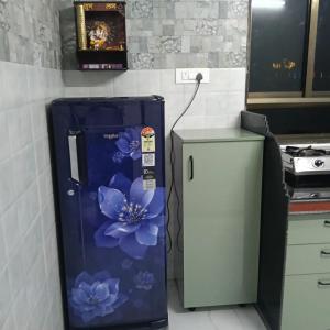 a refrigerator with blue flowers painted on it in a kitchen at Shivoham holiday villa in Dapoli