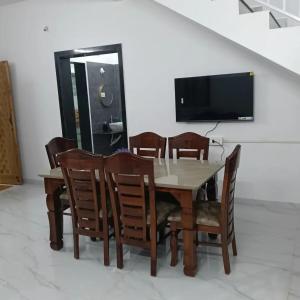a dining room with a table and chairs and a television at Shivoham holiday villa in Dapoli