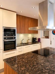 a kitchen with marble counter tops and wooden cabinets at Baleal Breeze Apartment in Ferrel