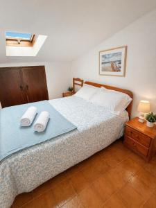 a bedroom with a bed with two towels on it at Baleal Breeze Apartment in Ferrel