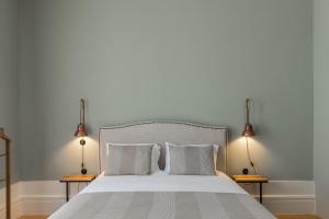 a bedroom with a large white bed with two lamps at GuestReady - Picaria Living Quarter 3 in Porto