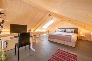 a bedroom with a bed and a desk in a attic at Tiny Bishorn mit privatem Whirlpool in Grächen