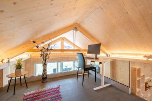 an attic office with a desk and a computer at Tiny Bishorn mit privatem Whirlpool in Grächen