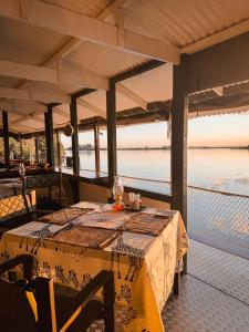 a table on a porch with a view of the water at Chobe House Villa and Chalets in Kasane