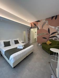 a bedroom with a large bed and a green chair at Hotel Ligure in Spotorno +274 photos