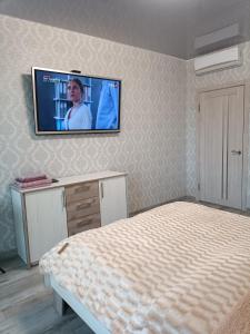 a bedroom with a bed and a tv on the wall at Апартаменти в ЦЕНТРІ ІМПЕРІАЛ in Truskavets