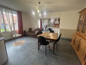 a living room with a table and a couch at Gîte à l'étable in Terdeghem +2 photos