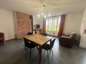 a living room with a wooden table and chairs at Gîte à l'étable in Terdeghem