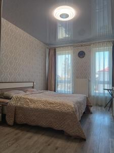 a bedroom with a large bed and a large window at Апартаменти в ЦЕНТРІ ІМПЕРІАЛ in Truskavets