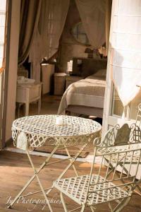 une table et une chaise dans une chambre avec un lit dans l'établissement Le jardin de Saint Jean, à Saint-Jean-aux-Bois