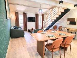 a dining room and living room with a table and chairs at cabane perche duplex st affrique in Saint-Affrique