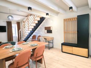 a dining room with a table and chairs and a staircase at cabane perche duplex st affrique in Saint-Affrique