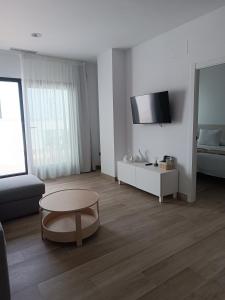 a living room with a table and a couch at Oliva Suite Apartamentos in Pozoblanco +37 photos