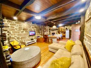 a living room with a couch and a stone wall at Casa da Azenha Branca in Castelo do Neiva