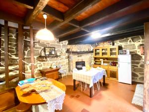 a kitchen with a table and a stone wall at Casa da Azenha Branca in Castelo do Neiva