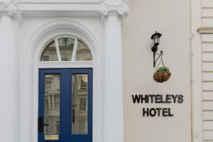 a white building with a blue door and a window at Whiteleys Hotel in London +84 photos