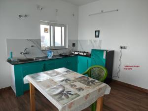 a green kitchen with a table and a sink at Abhi's Cottage in Mukteshwar +40 photos