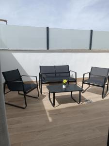 three black chairs and a table in a room at Oliva Suite Apartamentos in Pozoblanco