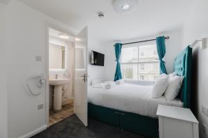 a bedroom with a bed and a sink and a window at Whiteleys Hotel in London