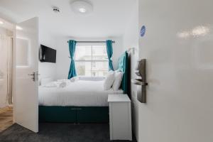 a bedroom with a bed and a window at Whiteleys Hotel in London