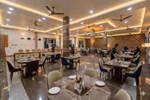 a restaurant with tables and chairs and people in the background at RS Resort in Ayodhya