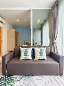 a brown couch with pillows in a living room at BLU Diamond Cha Am in Ban Bo Khaem +30 photos