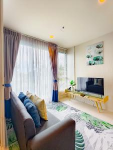 a living room with a couch and a television at BLU Diamond Cha Am in Ban Bo Khaem