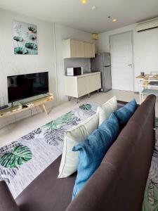 a living room with a couch and a tv at BLU Diamond Cha Am in Ban Bo Khaem