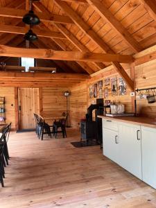 a kitchen and dining room of a log cabin at Glamping - Projekt Alpaka in Garbatka-Letnisko