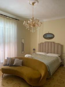 a bedroom with a couch and a bed with a chandelier at Villa Favorita Suites in Ercolano