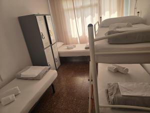 a room with three bunk beds and a window at Albergue La Corona1 in O Pino 