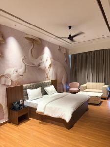 a bedroom with a large bed with an elephant mural on the wall at City Center Suites in Bhatinda