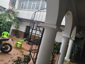 a spiral stairway in a house with a green chair at Avaroa 350 in Sucre