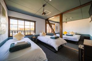 a room with two beds and a window at The Bears Lodge in Hakuba